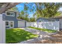 Charming two-story home with a well-manicured lawn and a white fence at 733 1/2 New Jersey St, Clearwater, FL 33756