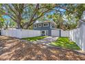 Charming two-story home with a well-manicured lawn and a white fence at 733 1/2 New Jersey St, Clearwater, FL 33756
