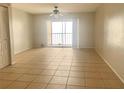 Spacious living room with tile floors and sliding glass doors to balcony at 5507 Pokeweed Ct # C, Tampa, FL 33617