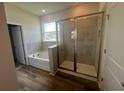Modern bathroom boasts a glass-enclosed shower and a separate soaking tub beneath a bright window at 16044 7Th E Ave, Bradenton, FL 34212