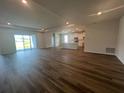 Spacious living room features wood-look flooring, recessed lighting, and sliding glass doors for natural light at 16044 7Th E Ave, Bradenton, FL 34212