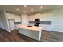 Modern kitchen featuring a large island, sleek countertops, stainless steel appliances, and ample cabinet space at 4303 Pullet Ct, Lakewood Ranch, FL 34211