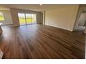 Open-concept living room with hardwood floors, large sliding glass doors, and natural light, perfect for entertaining at 4303 Pullet Ct, Lakewood Ranch, FL 34211