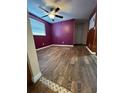 Simple bedroom with wood-look floors and purple walls at 8825 Sterling Ln, Port Richey, FL 34668