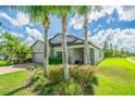 Two-story house with gray siding, landscaping, and a brick paver driveway at 19501 Sea Myrtle Way, Tampa, FL 33647