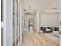 Bright foyer featuring wood floors, stylish lighting, and an open floor plan leading to the living area at 415 Islebay Dr, Apollo Beach, FL 33572