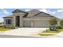 Attractive single-story home with stone accents, a well-manicured lawn, and an attached two-car garage at 12977 Long Valley Cir, Spring Hill, FL 34609