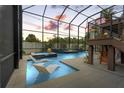 Screened swimming pool featuring water lounge chairs, a hot tub, waterfall, and a fire feature at 2600 Quincy S St, Gulfport, FL 33711