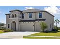 Attractive two-story home with a three-car garage and green lawn at 3437 Yellow Leaf Cir, Spring Hill, FL 34609