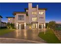 Night view of a modern home with a brick driveway at 490 Laguna Dr, Tierra Verde, FL 33715