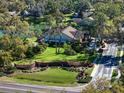 An aerial view of a beautiful home on a large lot with lush landscaping, a pool, and access to a nearby pond at 1105 Deer Run Pl, Valrico, FL 33594