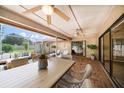 Spacious screened patio with a dining table, comfortable seating, and multiple ceiling fans at 1105 Deer Run Pl, Valrico, FL 33594