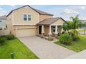 Inviting two-story home featuring a brick-paved driveway, attached two car garage and manicured front lawn at 11464 Chilly Water Ct, Riverview, FL 33569