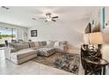 Spacious living room featuring a large sofa set, ceiling fan, and neutral tones at 11464 Chilly Water Ct, Riverview, FL 33569