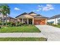 One-story house with orange garage door and landscaped yard at 6342 Kenava Loop, Palmetto, FL 34221