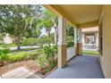 Covered front porch with white columns and a view of the street at 7806 Grasmere Dr, Land O Lakes, FL 34637