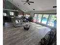 Bright open living room with wood floors, a stone fireplace, and sliding glass doors leading to the pool at 8945 Overlook Dr, Wesley Chapel, FL 33545