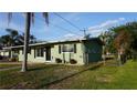 A cozy one-story home featuring well-kept front yard and painted in a pleasing, muted green tone at 5805 Oxford Dr, Tampa, FL 33615