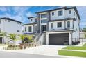 Modern two-story home with a gray stone facade and a spacious driveway at 6012 Kipps Colony E Dr, Gulfport, FL 33707