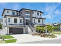 Stunning two-story home with modern design, gray stone accents, and a three-car garage at 6012 Kipps Colony E Dr, Gulfport, FL 33707