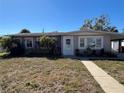 Quaint single-story home with palm trees and a covered carport adding functionality and charm at 15536 Bristol E Cir, Clearwater, FL 33764