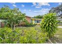 Attractive Florida home with lush landscaping and a vibrant yellow exterior at 1627 Dander Dr, Holiday, FL 34690
