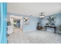 Bright living room with light blue walls and white tile floors at 1627 Dander Dr, Holiday, FL 34690