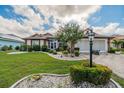 Single-Gathering home with manicured lawn, landscaping, and a paver driveway at 739 Winterbrooke Way, Sun City Center, FL 33573