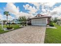 Single-Gathering home with paver driveway, landscaping, and a two-car garage at 739 Winterbrooke Way, Sun City Center, FL 33573
