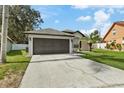 One-story house with a two-car garage and landscaped lawn at 9733 Long Meadow Dr, Tampa, FL 33615