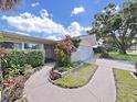 Well-maintained home showcasing landscaped curb appeal and a welcoming walkway to the front door at 1385 Embassy Dr, Clearwater, FL 33764