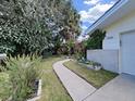 Landscaped front yard featuring a stone walkway, green grass, and established plants leading to the home's entrance at 1385 Embassy Dr, Clearwater, FL 33764