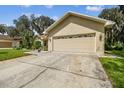 Tan two-car garage with a concrete driveway at 1905 Masters Way, Plant City, FL 33566