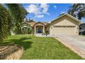 Tan one-story house with blue door and nicely landscaped yard at 1905 Masters Way, Plant City, FL 33566