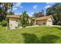 Tan one-story house with lush landscaping and a two-car garage at 1905 Masters Way, Plant City, FL 33566