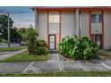 Evening view of a two-story townhome with orange trim and lush landscaping at 1655 58Th S Ter # 1, St Petersburg, FL 33712