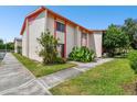 Side view of a two-story townhome with orange trim and lush landscaping at 1655 58Th S Ter # 1, St Petersburg, FL 33712