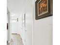 Bright hallway with light wood flooring and a framed picture on the wall at 1655 58Th S Ter # 1, St Petersburg, FL 33712