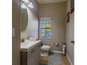 Modern half bathroom with a gray vanity and tiled floors at 10215 Count Fleet Dr, Ruskin, FL 33573