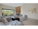 Inviting living room with ample light, a fireplace, and comfortable seating with a view of the balcony at 4251 Preserve Pl, Palm Harbor, FL 34685