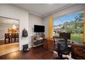 Home office features built-in shelving, hardwood floors, and view of backyard at 4940 Willow Ridge Ter, Valrico, FL 33596