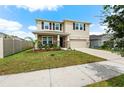 Two-story house with landscaped yard and large driveway at 8861 Forge Breeze Loop, Wesley Chapel, FL 33545