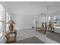 Bright living room with tile floors, large windows, and decorative table lamps and mirror at 8002 Lake Dr, Palmetto, FL 34221