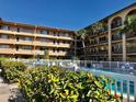 Community pool surrounded by lush tropical landscaping and condo building at 2525 W Bay Dr # B32, Largo, FL 33770