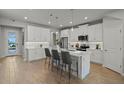 Modern kitchen with white cabinets, quartz countertops, and a large island at 31564 Woodland Race Loop, Wesley Chapel, FL 33545