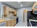 Kitchen with light wood cabinets and black appliances at 15215 Amberly Dr # 206, Tampa, FL 33647