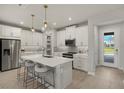 Modern kitchen with island, white cabinets and stainless steel appliances at 31556 Woodland Race Loop, Wesley Chapel, FL 33545