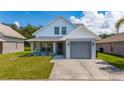 Charming two-story home with a gray garage, well-kept lawn and landscaping under blue skies at 10209 Summerview Cir, Riverview, FL 33578