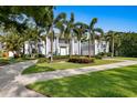 Elegant two-story home featuring white columns, lush landscaping, and a circular driveway at 45 Adalia Ave, Tampa, FL 33606