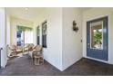 Inviting front porch with wicker chairs and a brick floor at 1029 Seagrape Dr, Ruskin, FL 33570